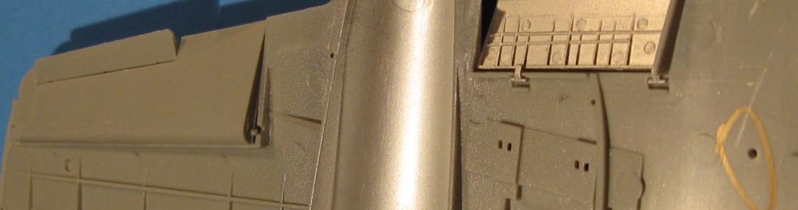 The flap hinge pins and wing sockets are visible on the trailing edge of the wing.