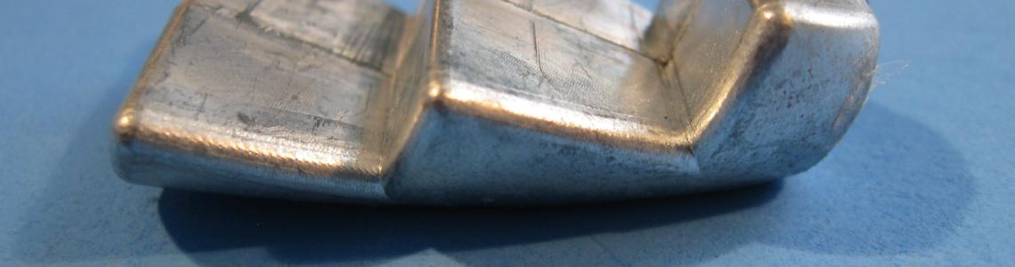 The nose weight is plenty heavy enough to keep the nose gear firmly down.  Small dimples in the both sides of the weight accept matching pins that firmly hold the weight in position in the fuselage interior. 