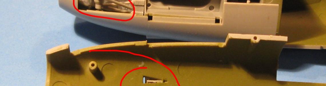 The upper red circle shows how I put the gear braces on the wrong side.  The brace should be on the other side (interior).   The cast nose weight is nicely done and fit snugly in position.  The small gun barrels are highlighted by the lower red circle